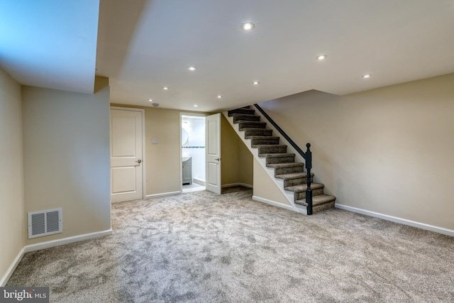 basement featuring light carpet