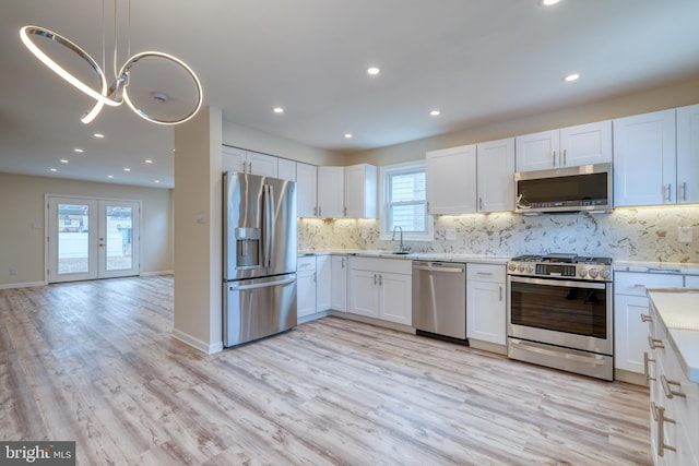 kitchen with appliances with stainless steel finishes, sink, and white cabinets