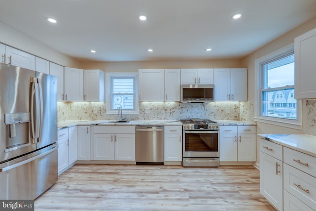 kitchen with sink, stainless steel appliances, and white cabinets