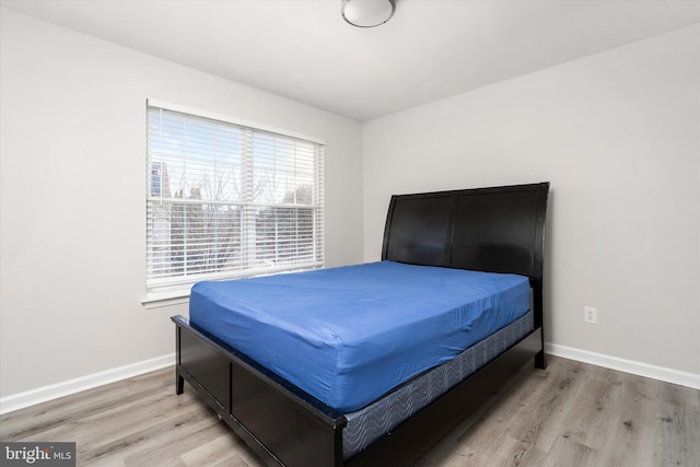 bedroom with light wood finished floors and baseboards