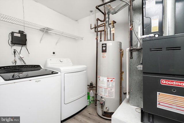 laundry room with laundry area, light wood-style floors, water heater, heating unit, and washer and clothes dryer