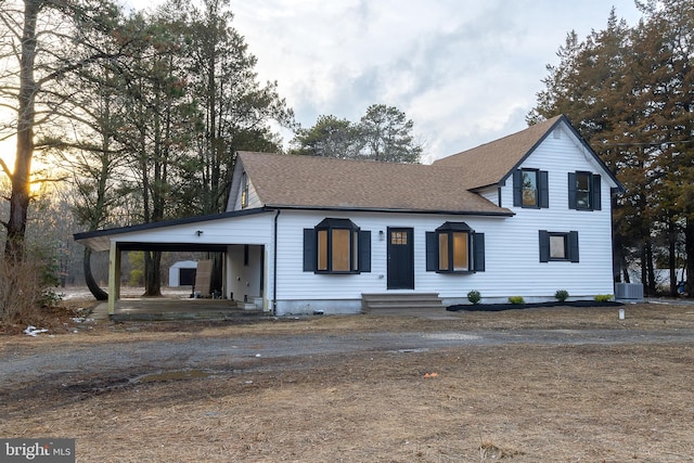 view of front facade with cooling unit and a carport