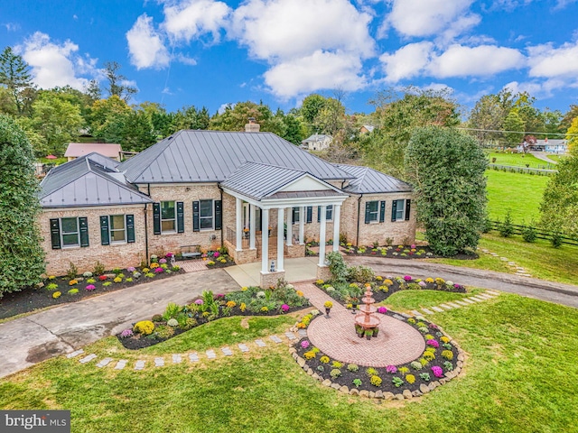 view of front of property with a standing seam roof, metal roof, fence, and aphalt driveway