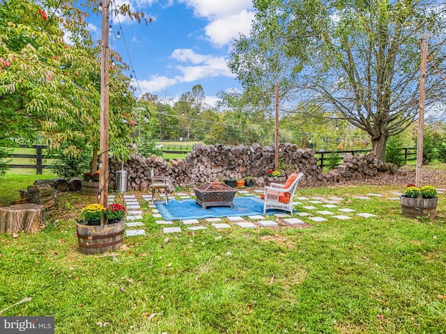 view of yard with a fire pit, a patio area, and fence