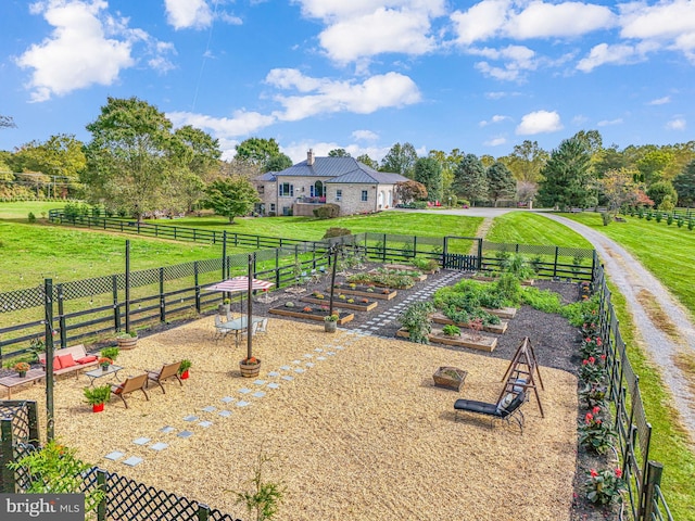 view of yard featuring a rural view, fence, and a garden