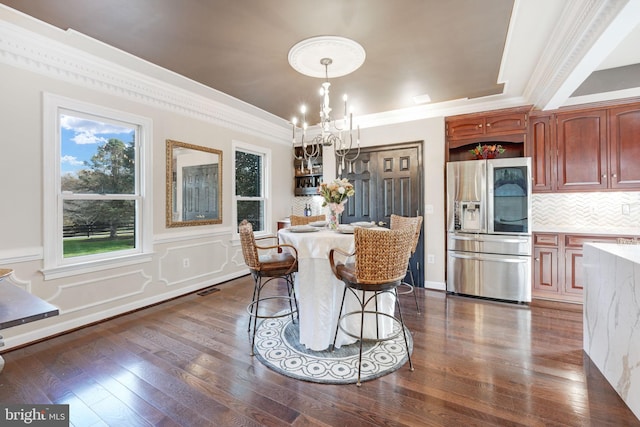 dining room featuring visible vents, a raised ceiling, dark wood-type flooring, an inviting chandelier, and crown molding