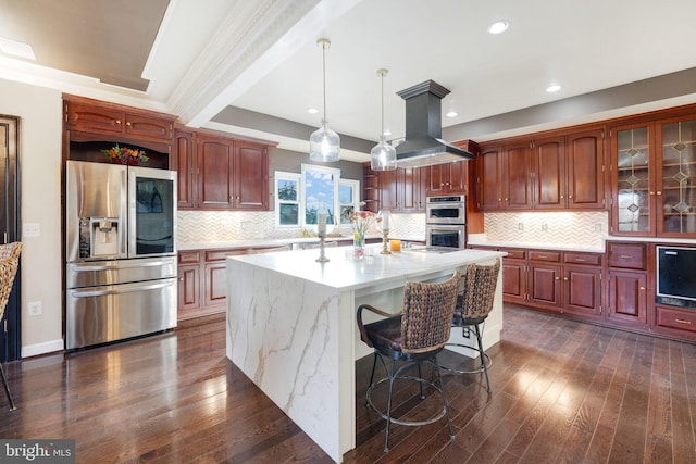 kitchen with dark wood-style flooring, decorative light fixtures, island exhaust hood, decorative backsplash, and appliances with stainless steel finishes