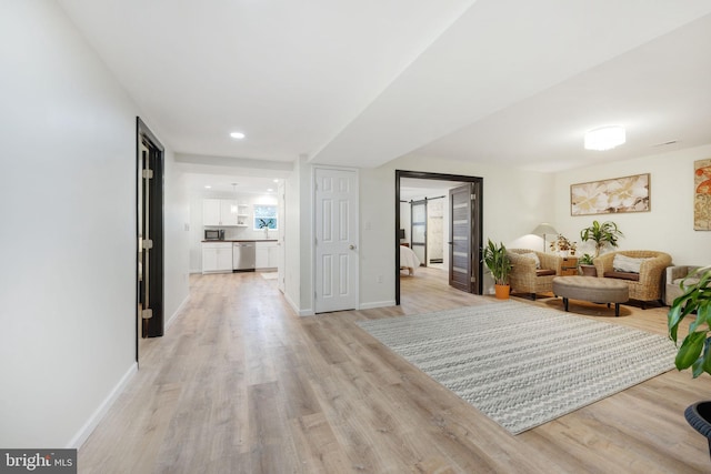 living area with light wood-type flooring and baseboards