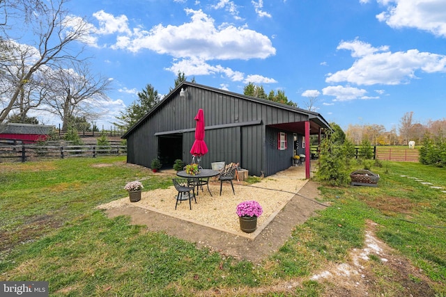 view of pole building with a yard, an outdoor fire pit, and fence