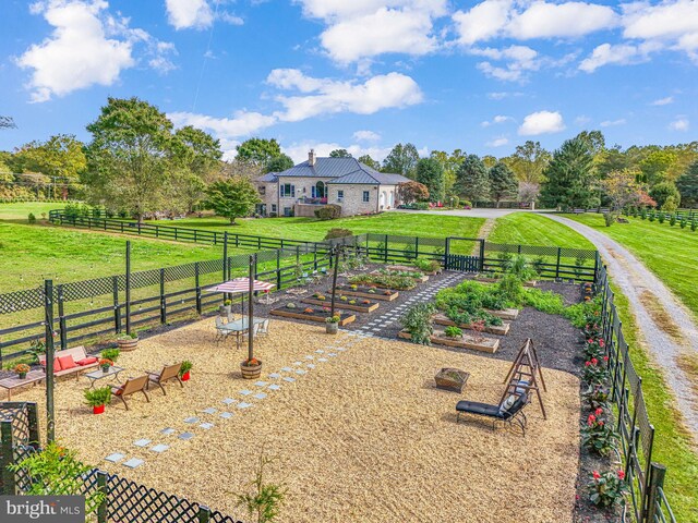 view of yard featuring a rural view, a vegetable garden, and fence