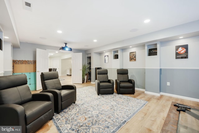 cinema room featuring baseboards, visible vents, wood finished floors, and recessed lighting