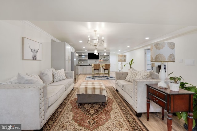 living area featuring light wood-style floors, recessed lighting, a chandelier, and crown molding