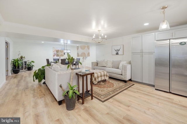 living room with recessed lighting, crown molding, light wood finished floors, and an inviting chandelier