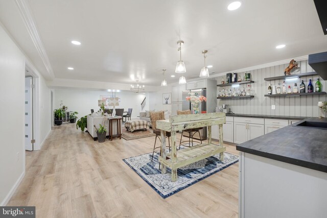 kitchen with crown molding, open shelves, dark countertops, freestanding refrigerator, and white cabinetry