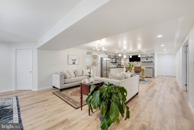 living area featuring light wood-type flooring, baseboards, a notable chandelier, and recessed lighting