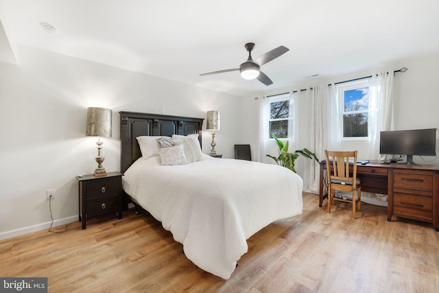 bedroom with light wood-style floors, ceiling fan, and baseboards