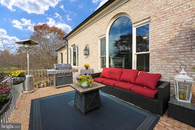 wooden deck with an outdoor hangout area and a grill