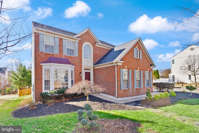 view of front facade with a front yard and brick siding