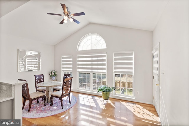 dining space with lofted ceiling, wood finished floors, and a ceiling fan