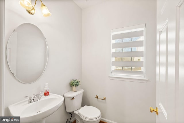 half bath featuring toilet and a sink