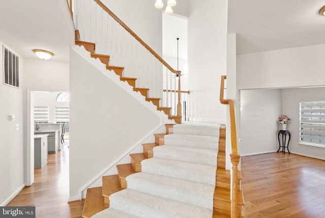 stairs with visible vents and wood finished floors