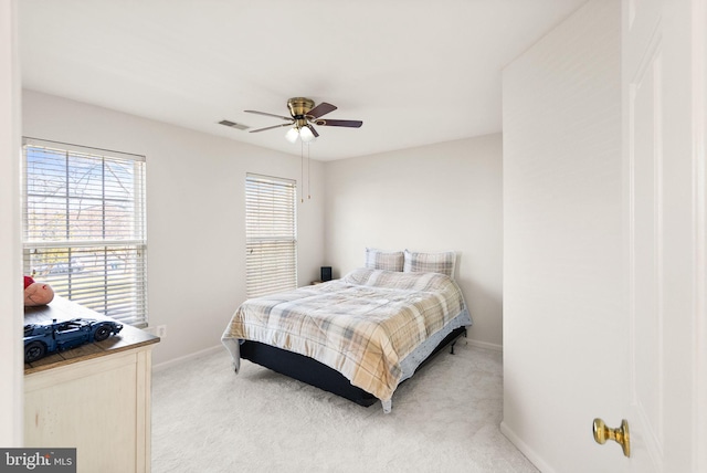 bedroom with baseboards, ceiling fan, visible vents, and light colored carpet