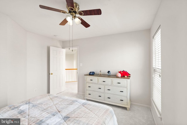 bedroom with ceiling fan, baseboards, and light colored carpet