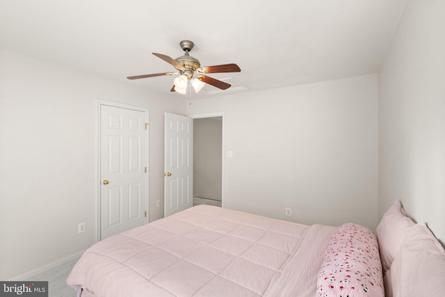 carpeted bedroom with ceiling fan and baseboards