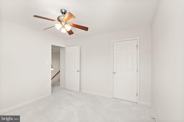 unfurnished bedroom with baseboards, a ceiling fan, and light colored carpet