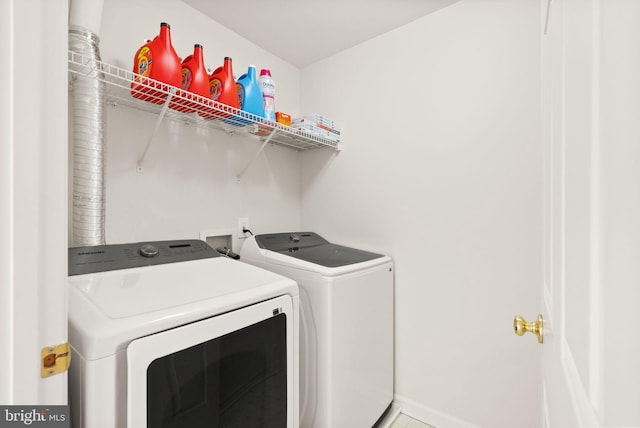 washroom with laundry area, baseboards, and washing machine and clothes dryer