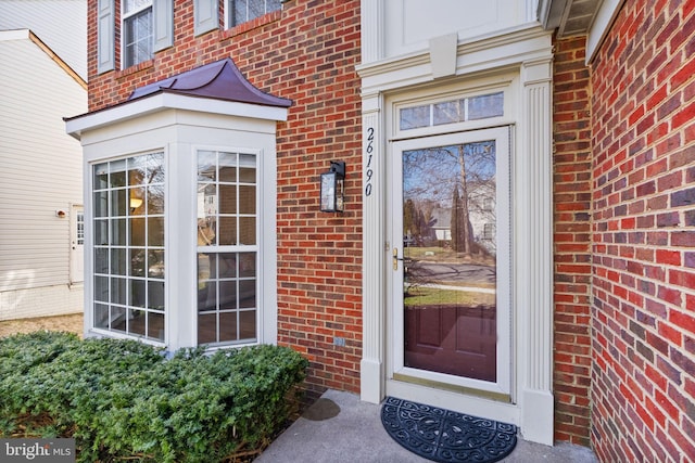 doorway to property featuring brick siding