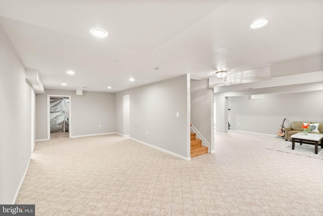 finished below grade area with stairs, baseboards, light colored carpet, and recessed lighting