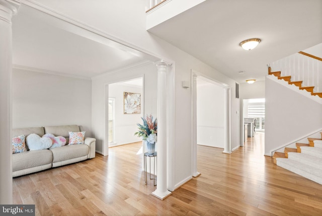 interior space featuring light wood-style floors, decorative columns, and stairway