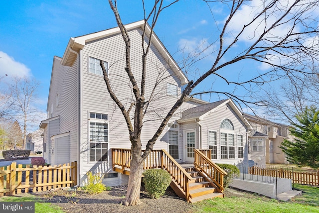 back of house featuring fence and a wooden deck