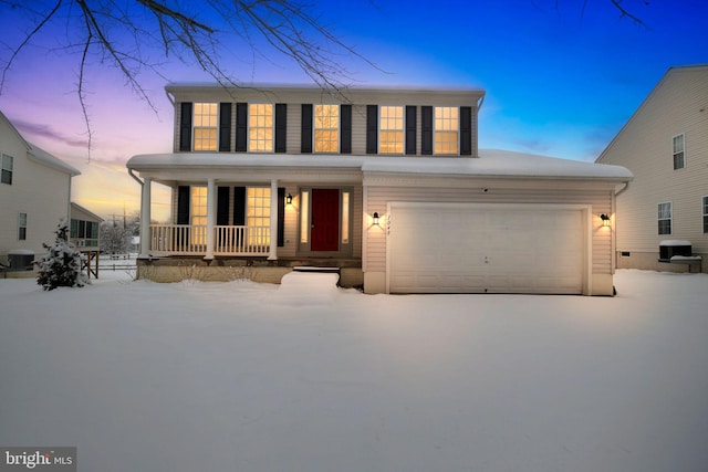 view of front of house with a garage, central AC, and covered porch