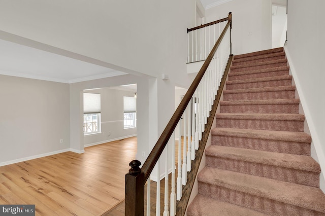 stairs featuring crown molding and hardwood / wood-style flooring