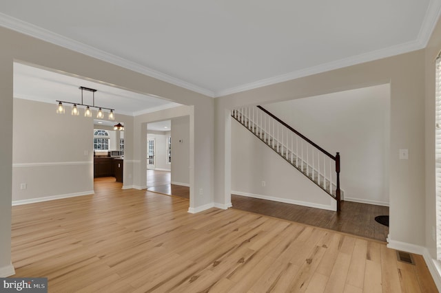 unfurnished living room featuring ornamental molding and light hardwood / wood-style floors