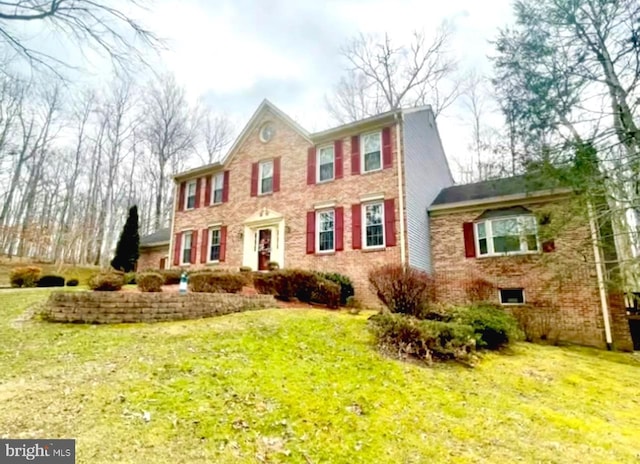 colonial-style house with a front lawn and brick siding