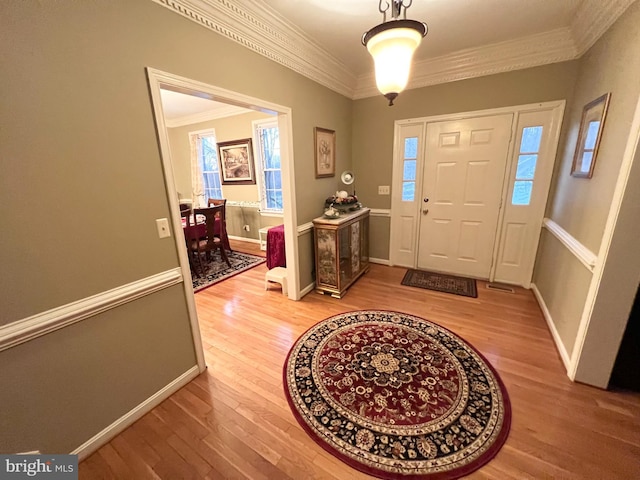 foyer featuring ornamental molding, baseboards, and wood finished floors