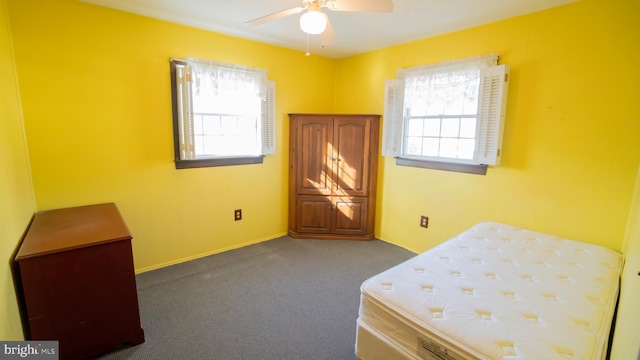 carpeted bedroom featuring multiple windows and ceiling fan