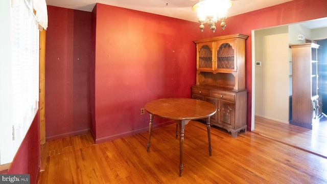 dining room featuring baseboards, an inviting chandelier, and light wood-style flooring