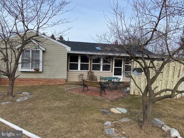 back of house featuring a patio, a chimney, and fence