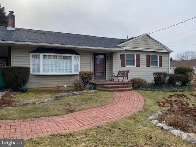 single story home with a front yard and a chimney