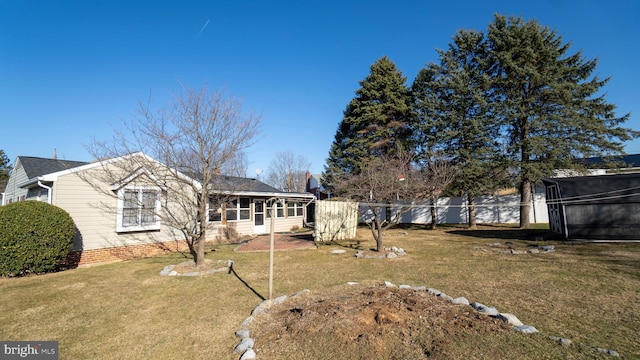 exterior space with fence, a front lawn, and a sunroom