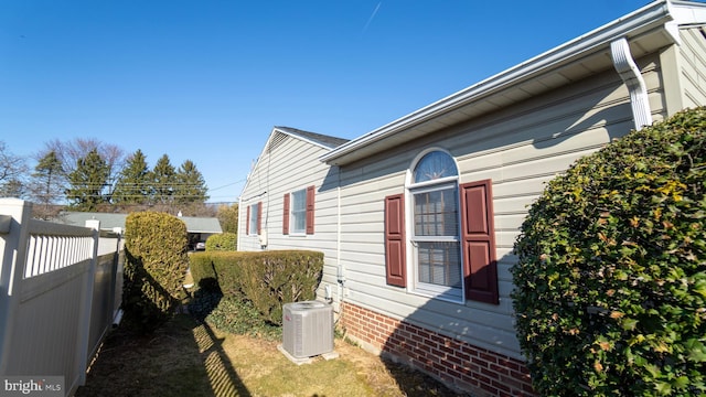 view of home's exterior with fence and central AC