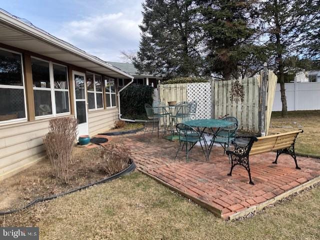 exterior space featuring outdoor dining space and fence