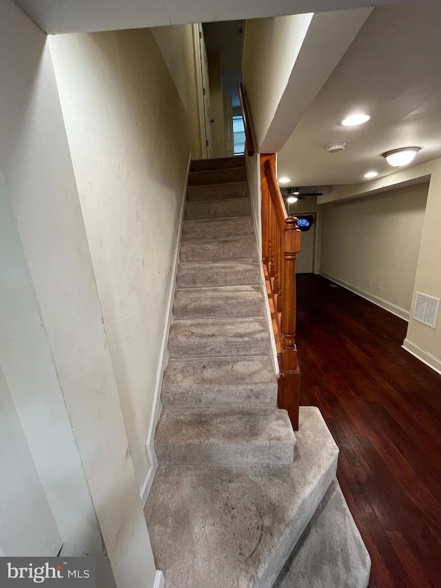 staircase with hardwood / wood-style floors