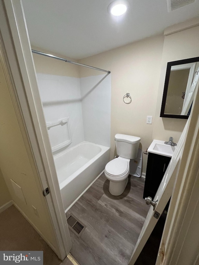 full bathroom featuring toilet, vanity, wood-type flooring, and shower / bath combination