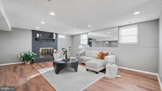 living room with baseboards, a brick fireplace, a healthy amount of sunlight, and wood finished floors