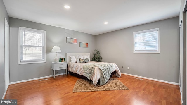 bedroom featuring recessed lighting, visible vents, light wood-style flooring, and baseboards